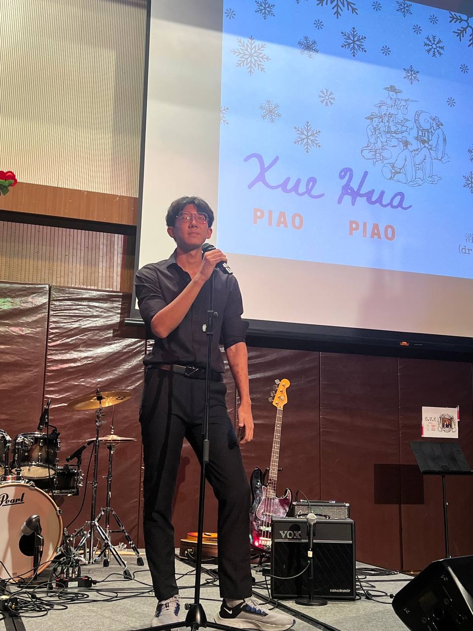 Shan Yuxuan singing into a microphone on stage